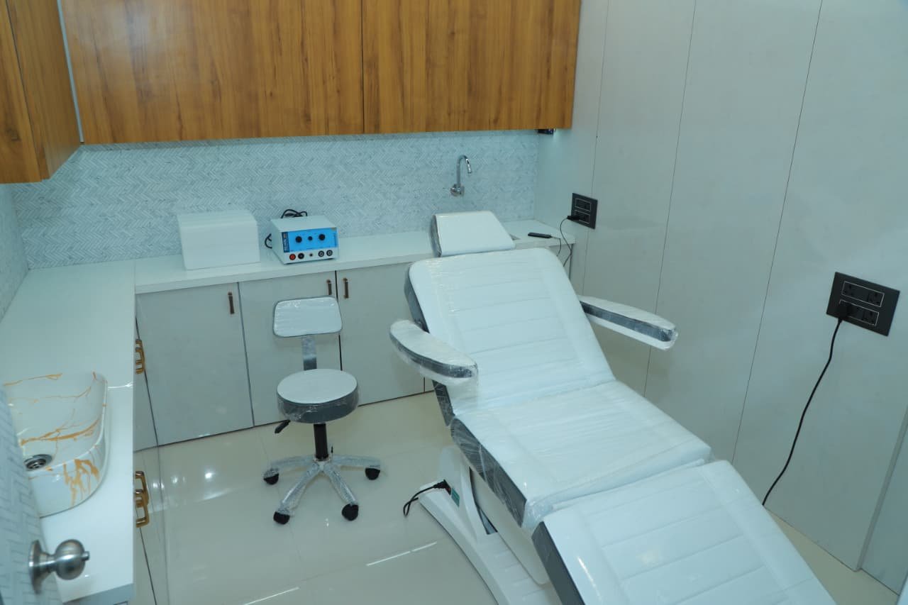 Examination desk and diagnostics equipment room at Sindhu Skin Clinic